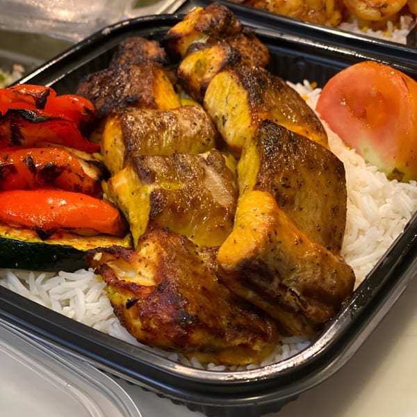 Nora's Kabob chicken and vegetable platter with rice, grilled peppers, zucchini, and tomato.